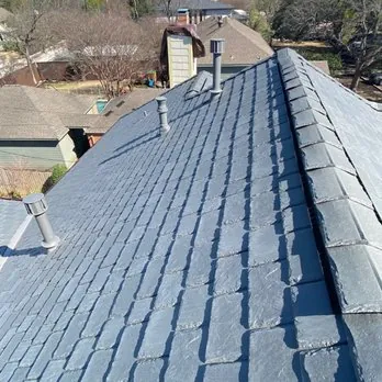 Gray roof covering with ridge caps and roof penetrations